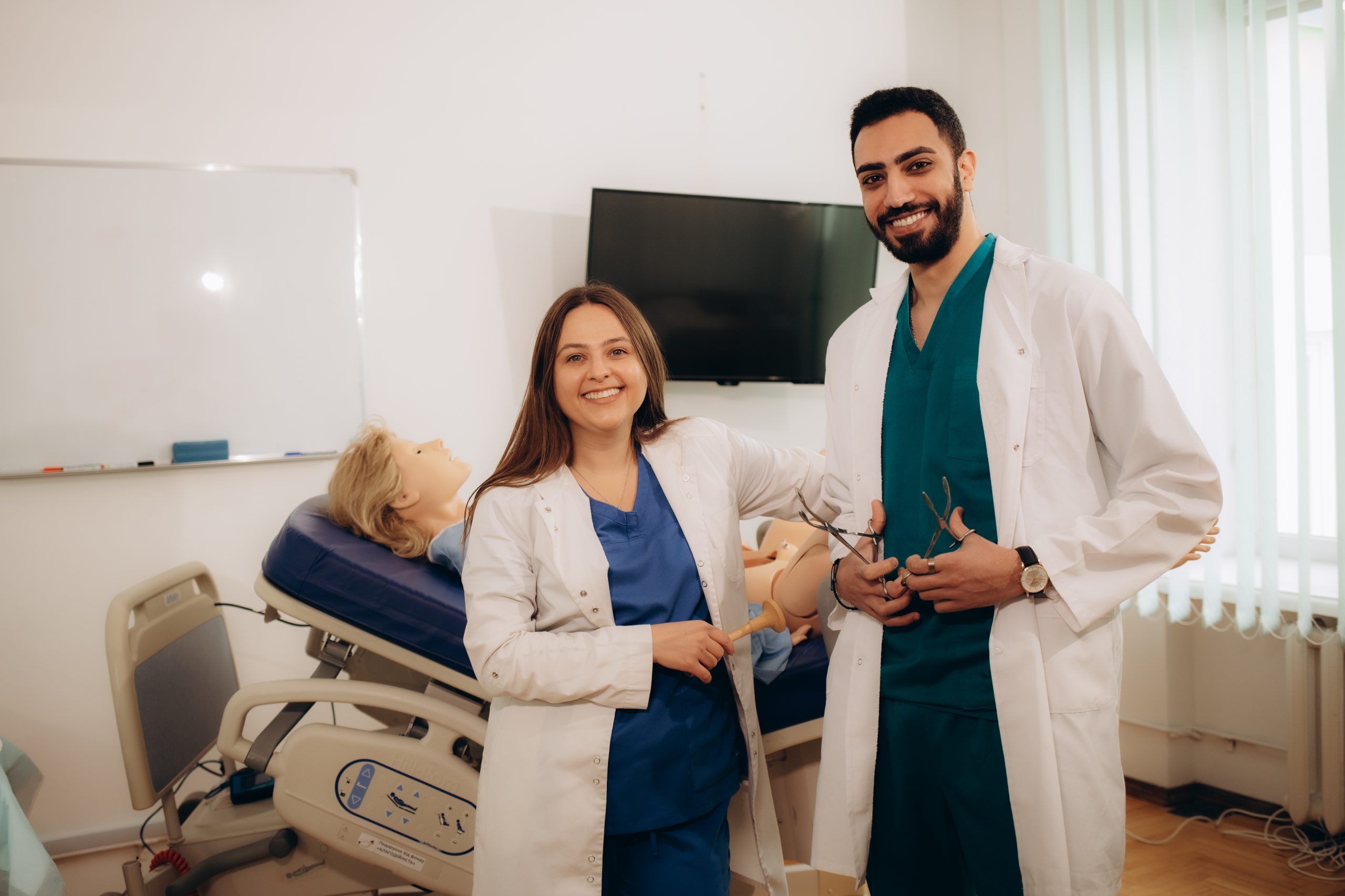 Obstetrician and gynaecologist with a student in front of a mannequin of a pregnant woman